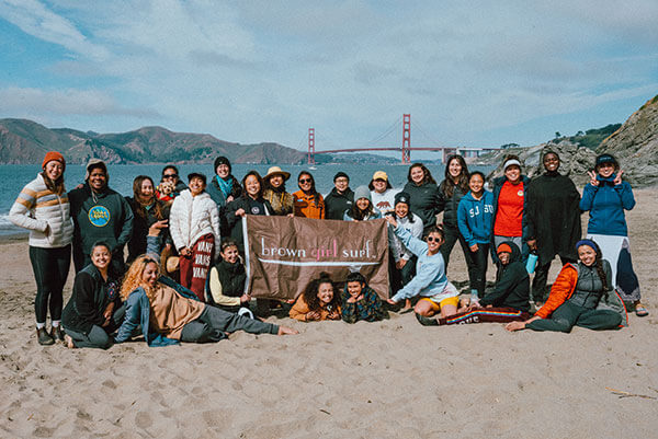 group on beach with sign